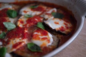 Fette di melanzane grigliate con salsa di pomodoro e mozzarella in una parmigiana leggera.