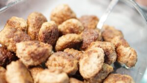 Polpette morbide appena sfornate su un piatto, guarnite con prezzemolo fresco.